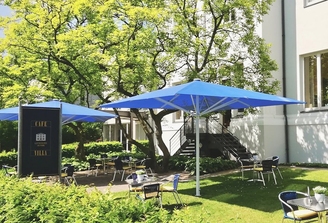 Biergarten des Cafe Villa im Convenio Gelsenkirchen mit blauen Sonnenschirmen