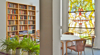 Bibliothek im Convenio Gelsenkirchen mit Bücherregal, Leseplätzen und Bleiglasfenster